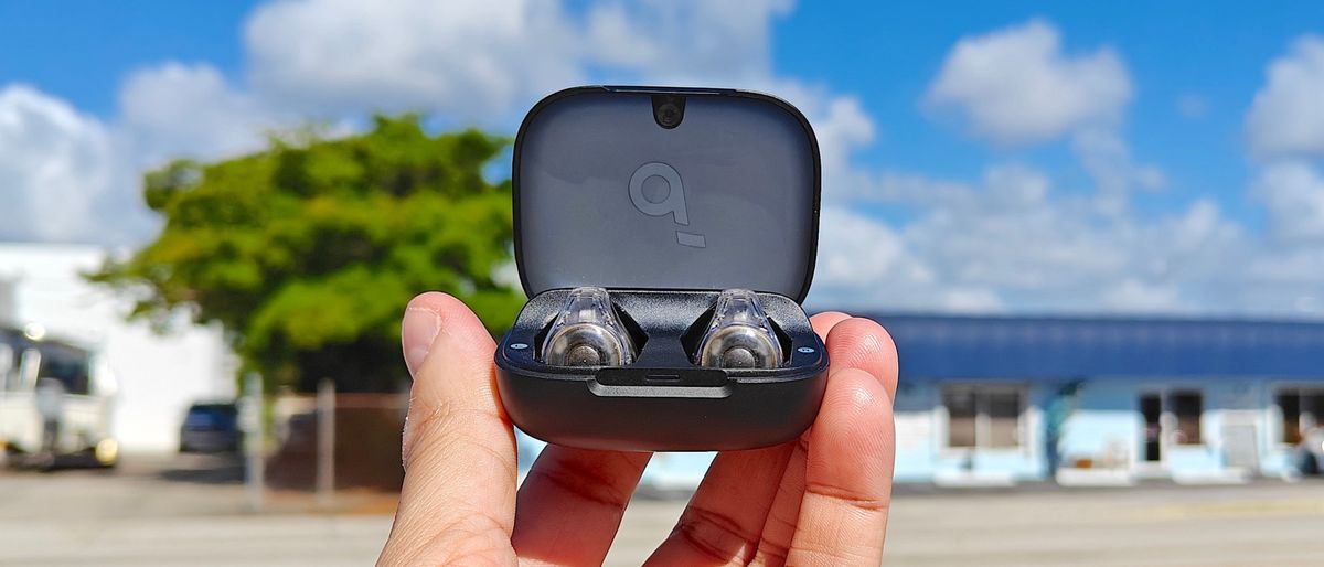 Anker Soundcore C30i in charging case held up against a blue sky