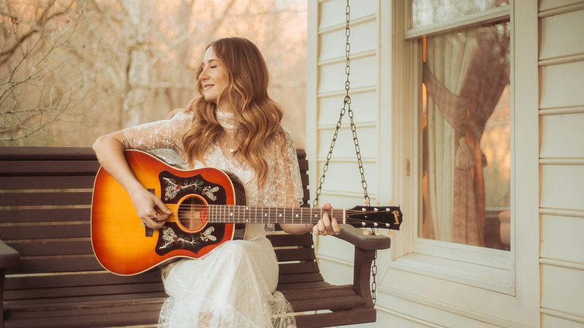 Margo Price sits on an outdoor swing bench playing her sunburst Gibson J-45