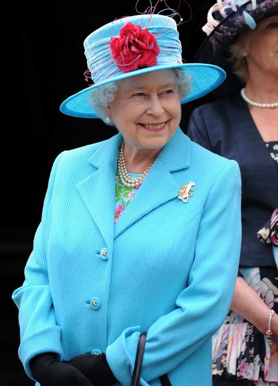 Queen Elizabeth II in a matching bright blue jacket and hat