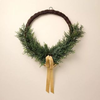 Faux Cedar Hoop Christmas Wreath against a cream background.