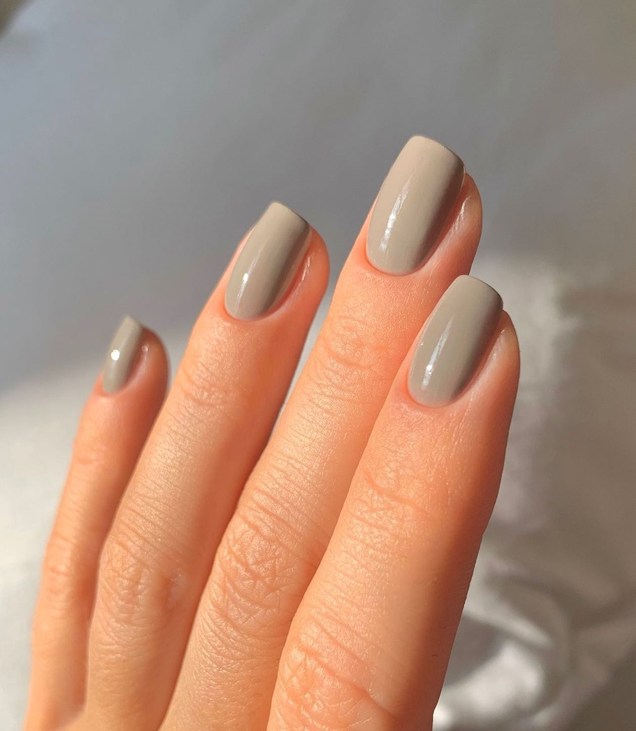 A light grey, square-shaped manicure