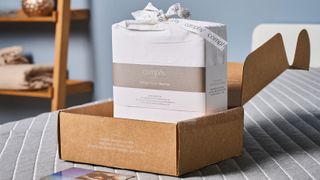 Coop Percale sheet set in the package placed on the bed in TG slep studio