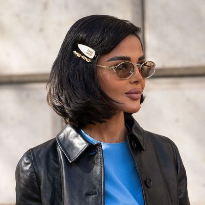 Mariam Mohammad wears a Miu Miu jacket, dress, sunglasses and hair clips 