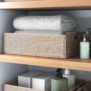 Woven baskets on shelf in bathroom with towels