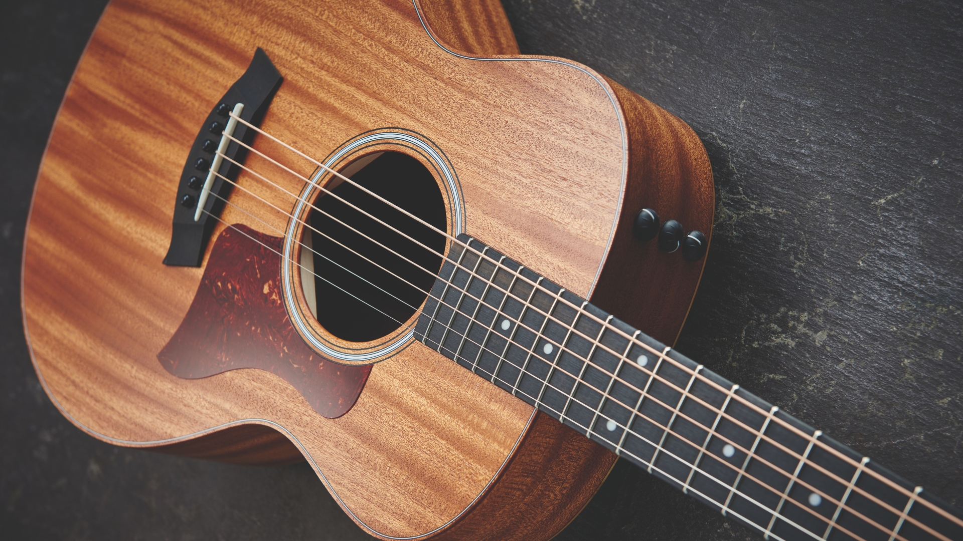 A Taylor GS Mini-e Mahogany lying on a wooden floor