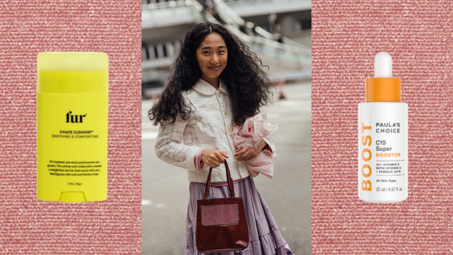 a woman with dark curly hair holding a maroon bag on a pink mica background with two skincare bottles next to her