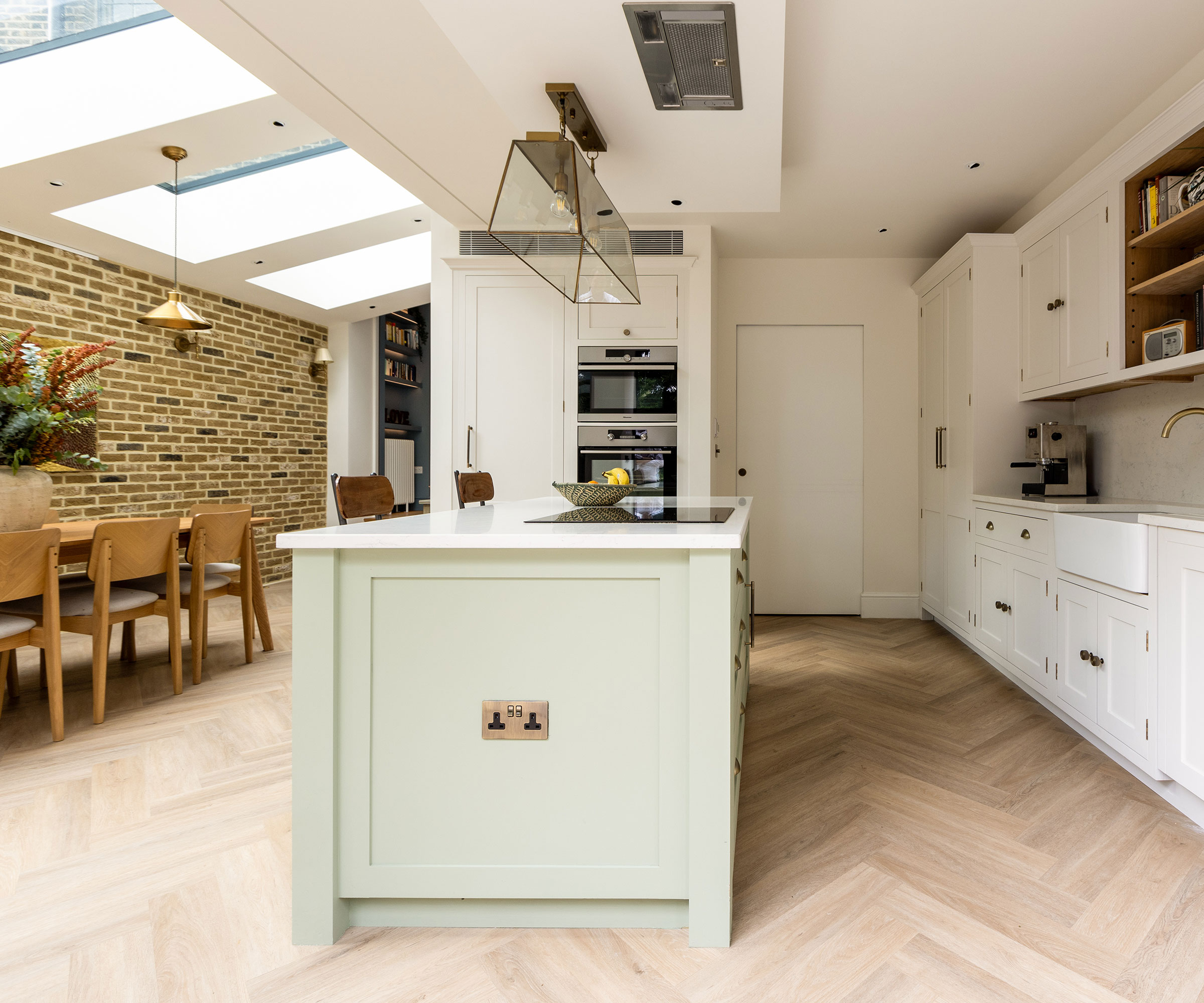 side return kitchen extension interior with white kitchen and herringbone flooring