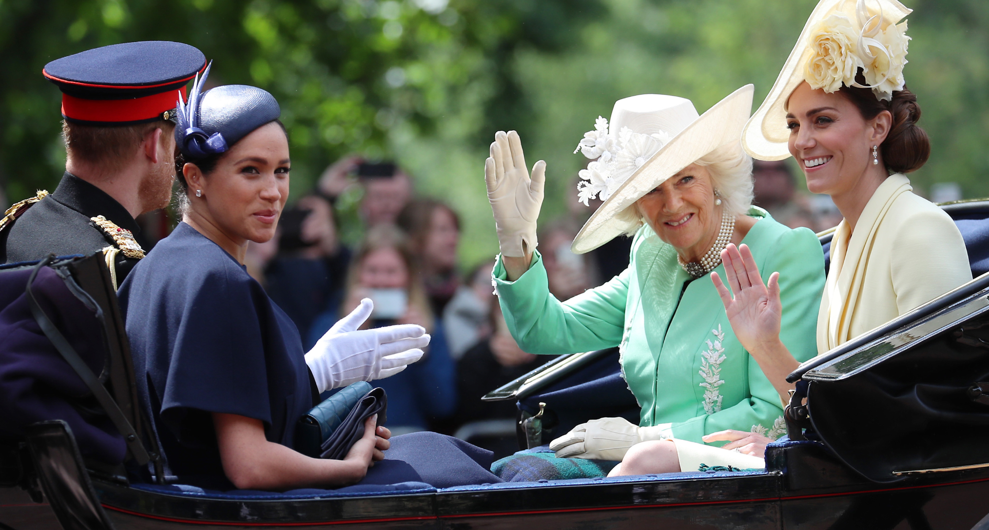 Queen Camilla, Princess Kate, Prince Harry and Meghan Markle riding in a carriage