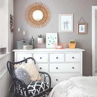 Grey bedroom wall with white chest of drawers