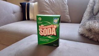 Box of baking soda by sofa