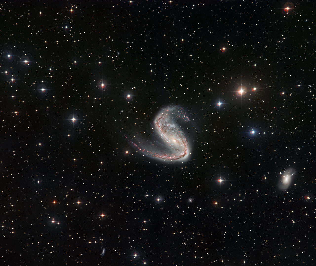 This picture of the Meathook Galaxy (NGC 2442) was taken by the Wide Field Imager on the MPG/ESO 2.2-metre telescope at La Silla, Chile. It shows a much broader view than the Hubble image, although less detailed. This view includes the whole galaxy and the surrounding sky, and clearly shows the asymmetric spiral arms.