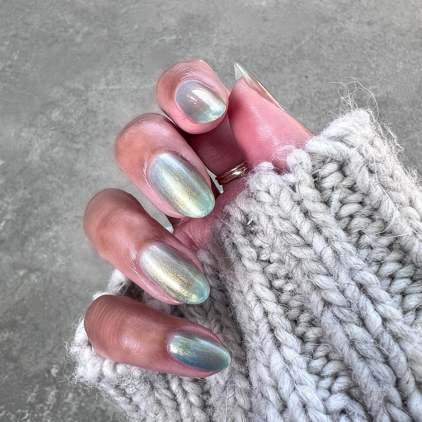 Person wearing iridescent blue-green jelly nail polish.