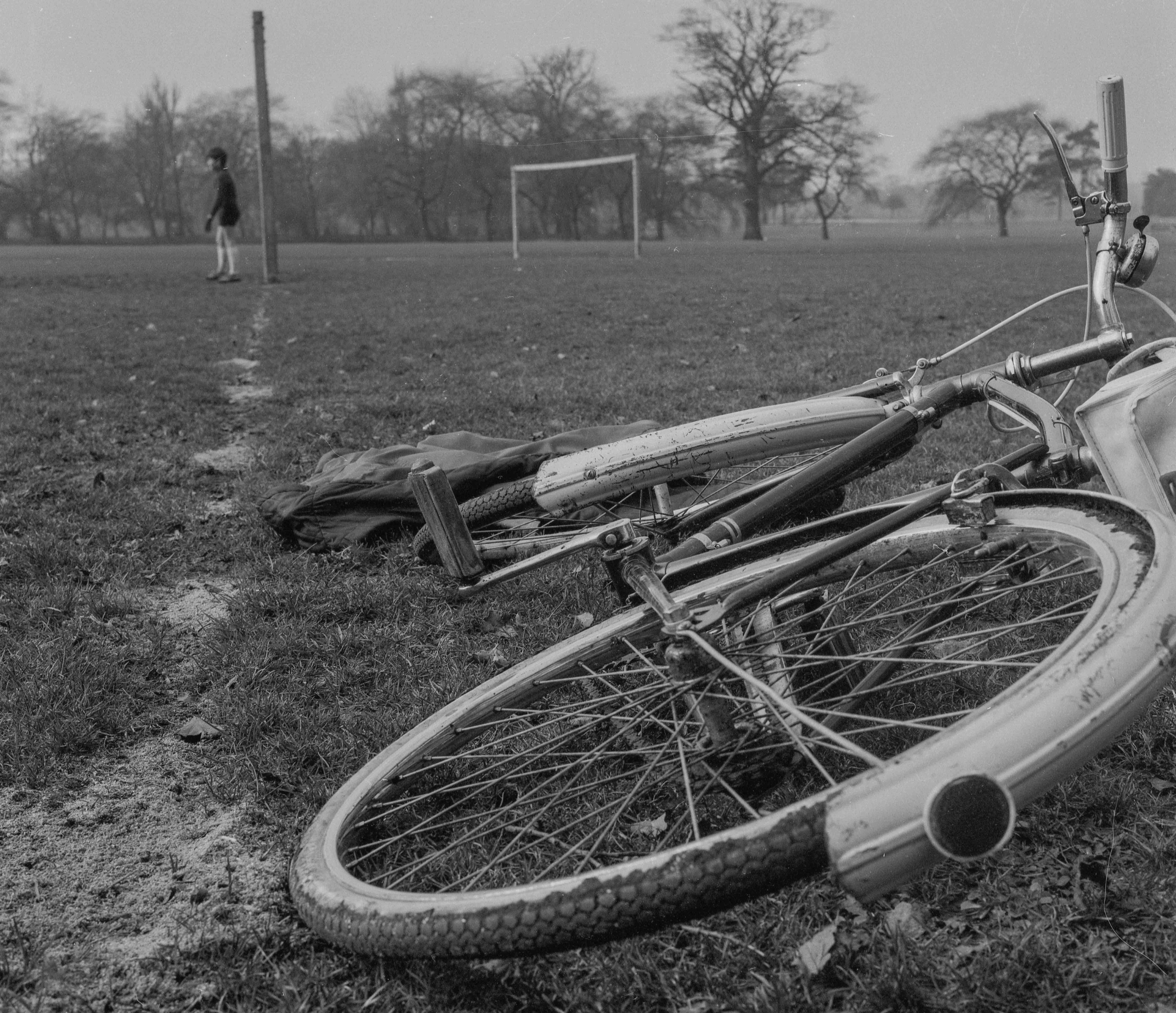 Bike in foreground, kids playing football in background.