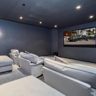 cinema room with white couch and screen