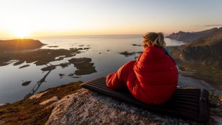 best women's sleeping bags: women in sleeping bag watching sunset