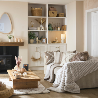 a cosy living room with a sofa layered with throws and cushions