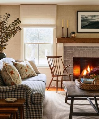 cozy living room with gingham sofa, fireplace and wooden furniture