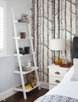 bedroom with tree textured wallpaper and wooden flooring
