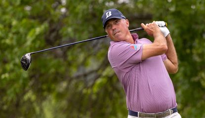 Kuchar watches his tee shot after striking a driver