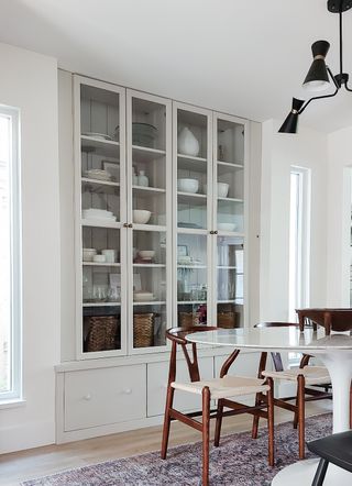 A white, built-in cabinet in the dining room