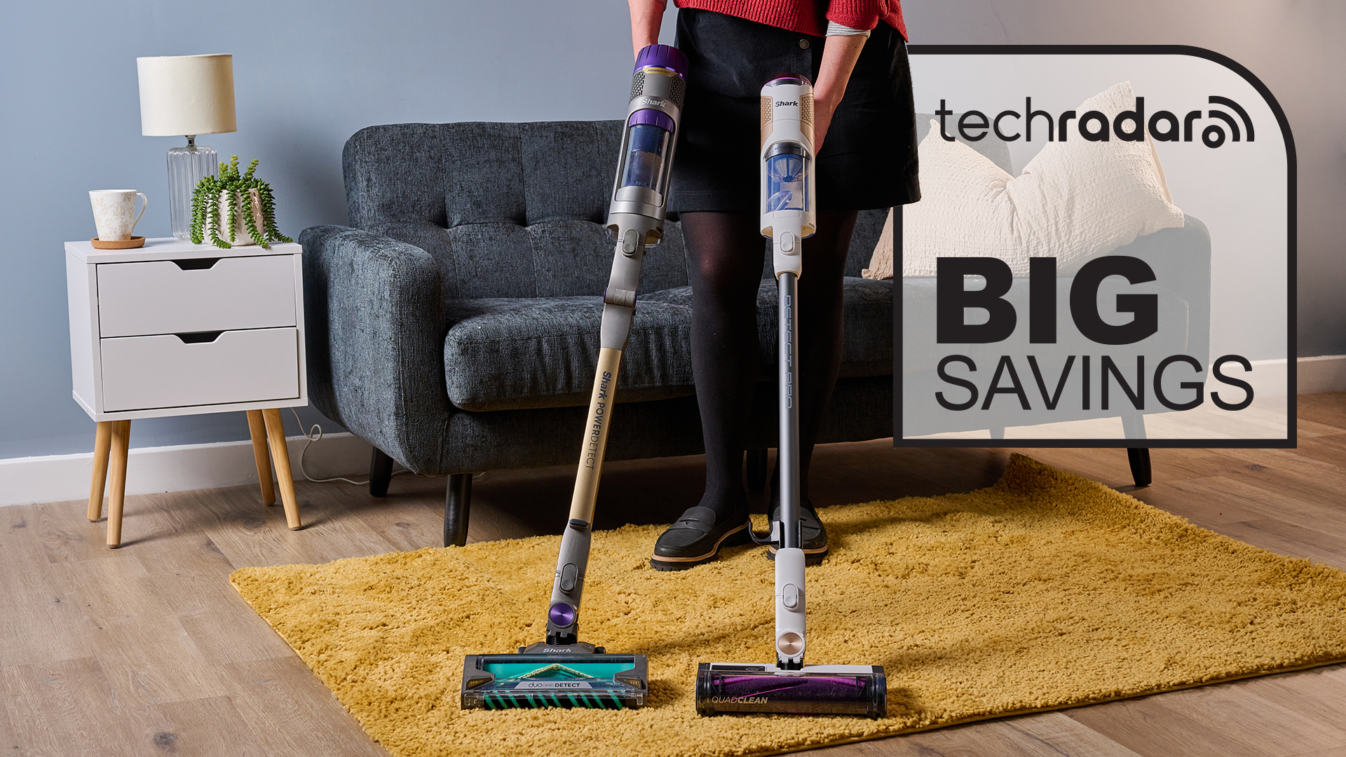 Person holding two cordless Shark vacuums, with Big savings graphic overlaid