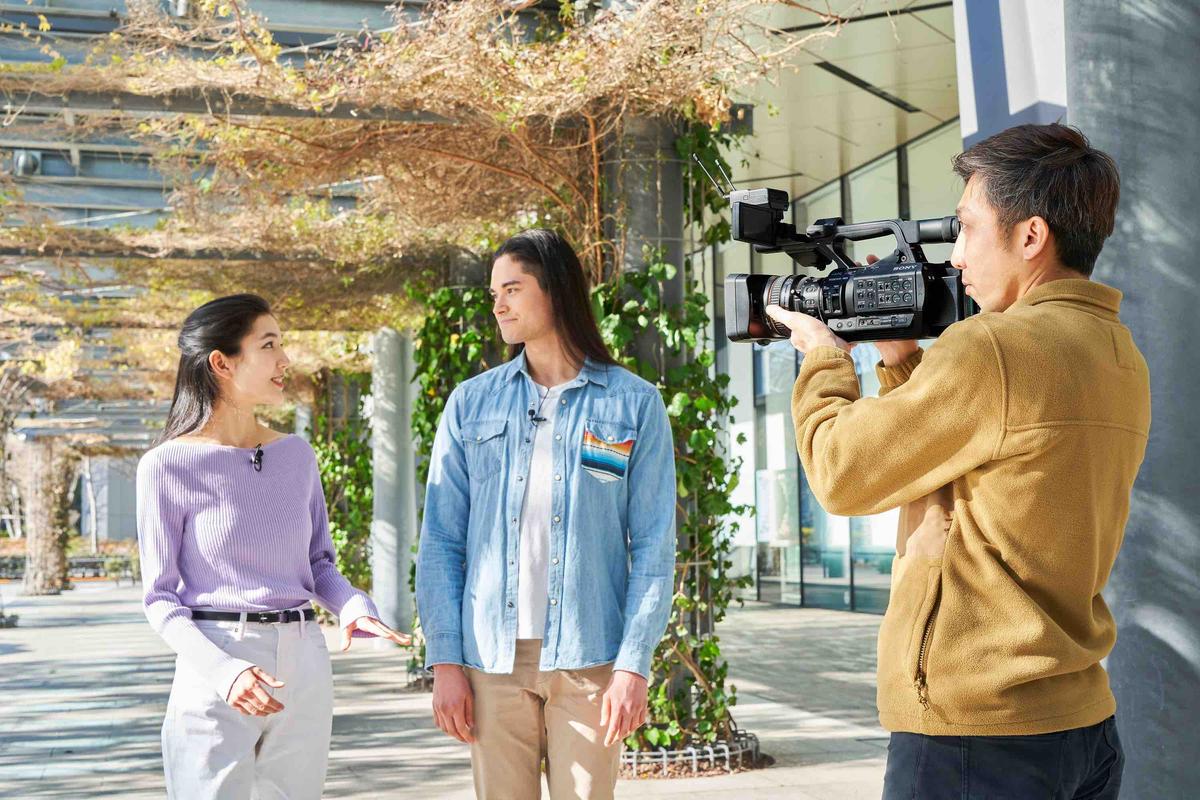 Man with Sony camera shooting two young women