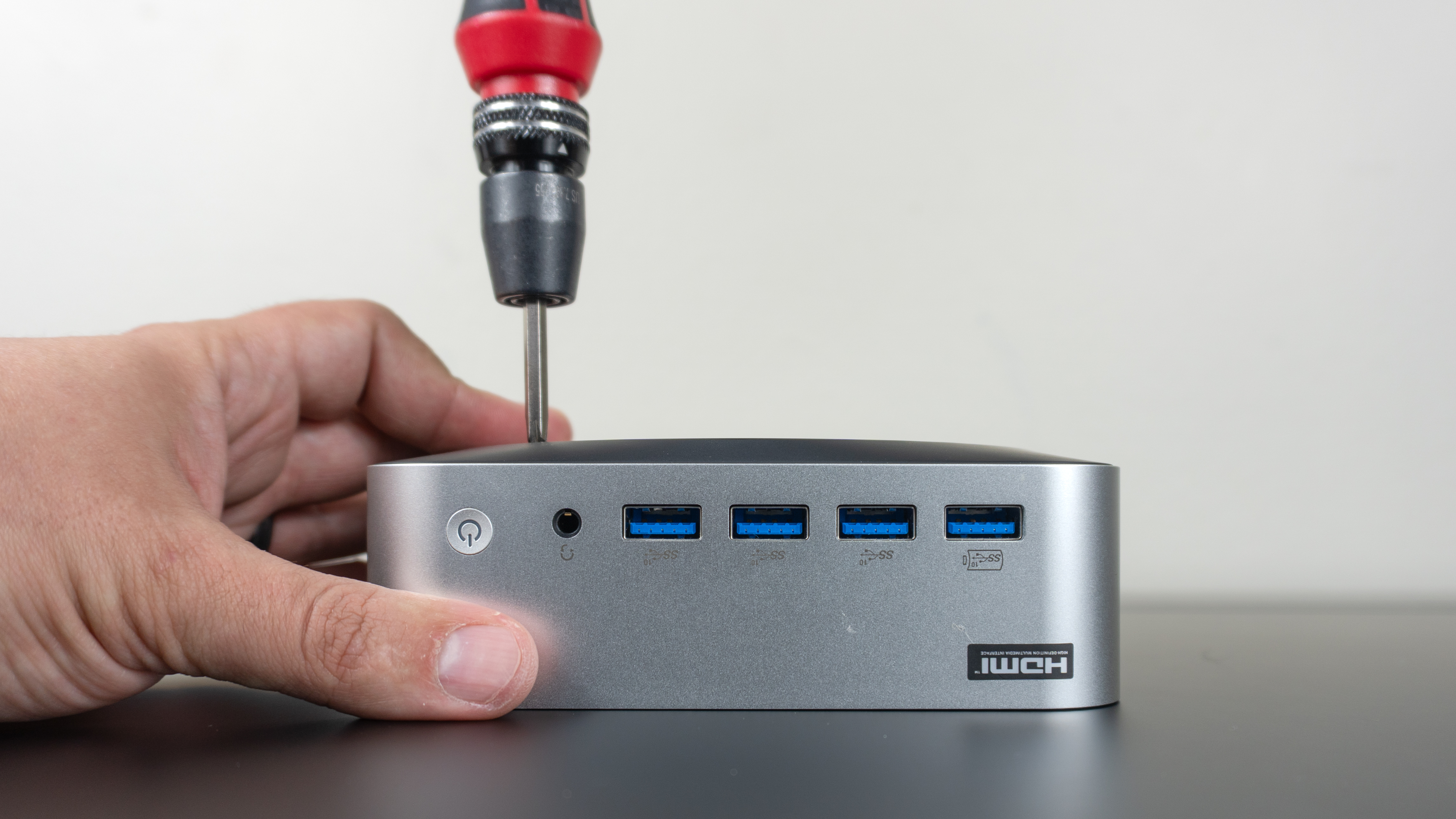 A person opening the Geekom A9 Max 2026 Edition up with a screwdriver