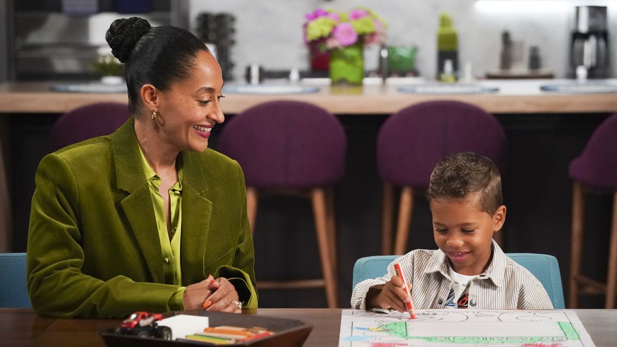 Tracee Ellis Ross looking at a young boy drawing in black-ish