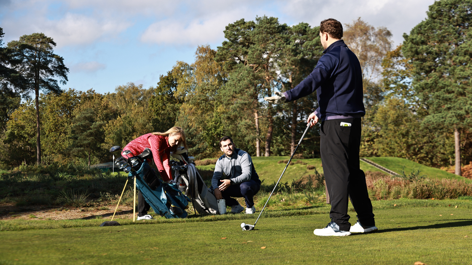 A golfer reacts after his playing partners look through their golf bag
