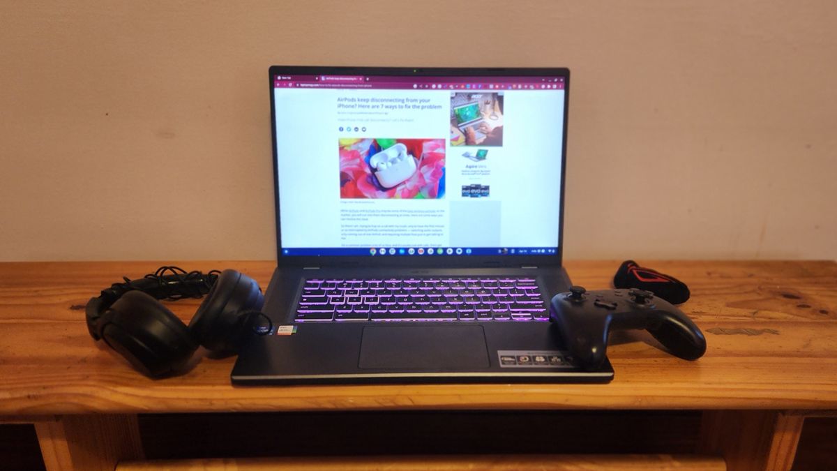 The Acer Chromebook 516 GE facing forward on a desk with gaming accessories like a gamepad and headset.