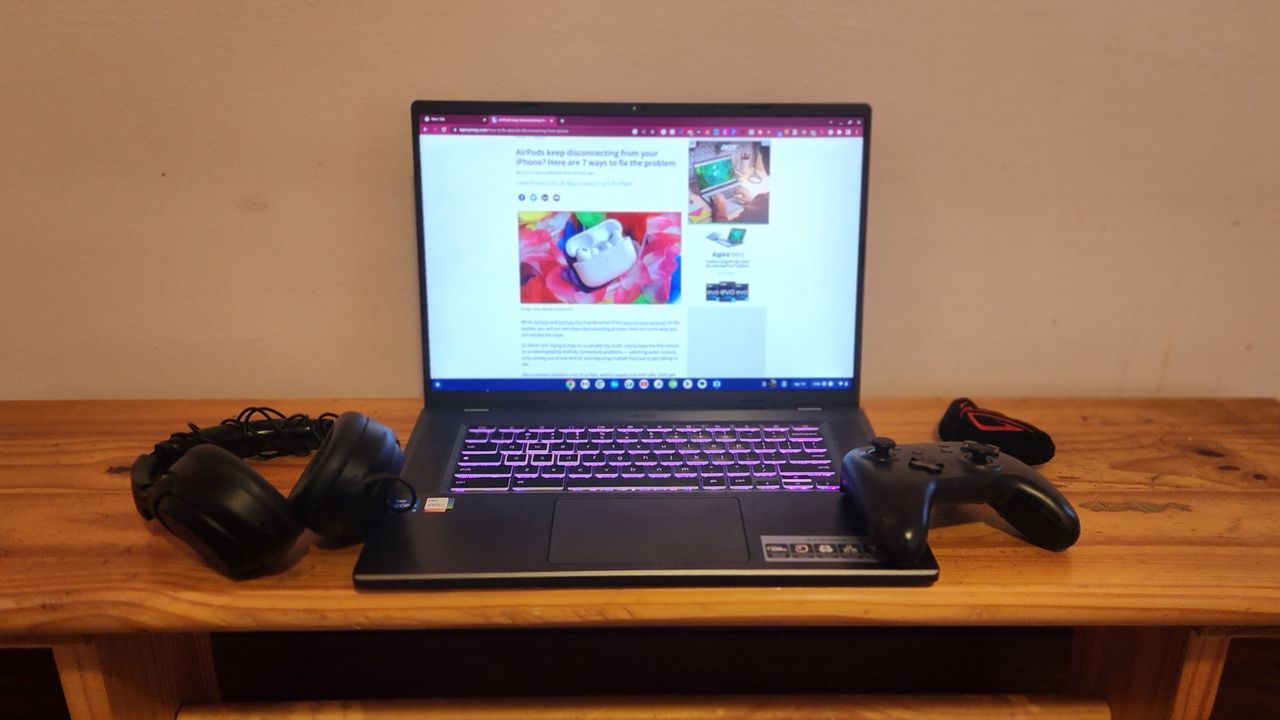 The Acer Chromebook 516 GE facing forward on a desk with gaming accessories like a gamepad and headset.