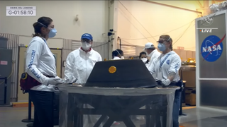 The team stands around the sample before putting it into the clean room.