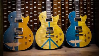 Three custom-made Gibson Les Paul guitars featuring the colors of the Ukrainian flag