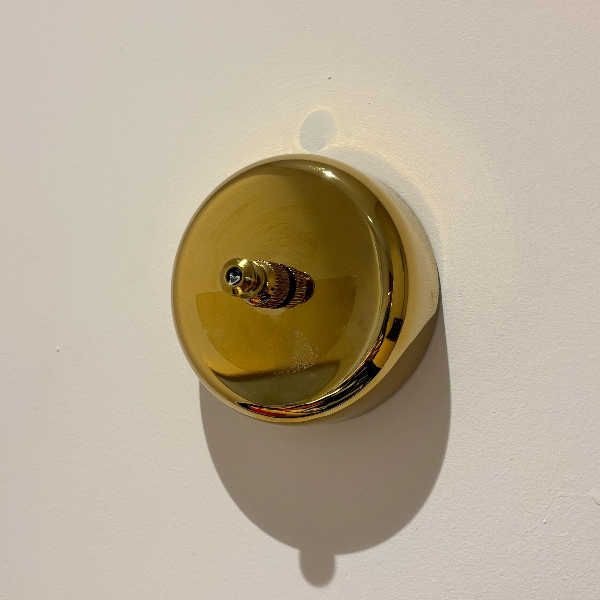 brass retractable clothes line on a pink wall