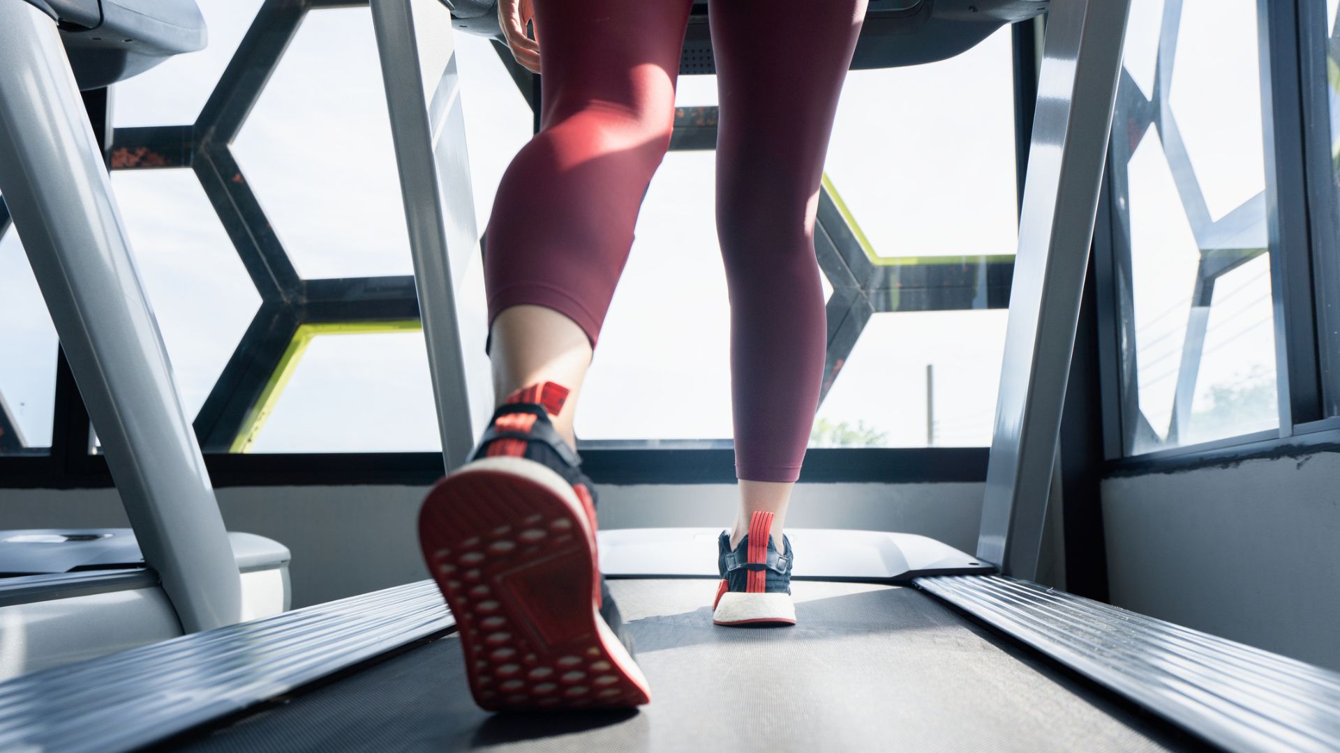 Back of woman's legs walking on a treadmill, doing Couch to 5k
