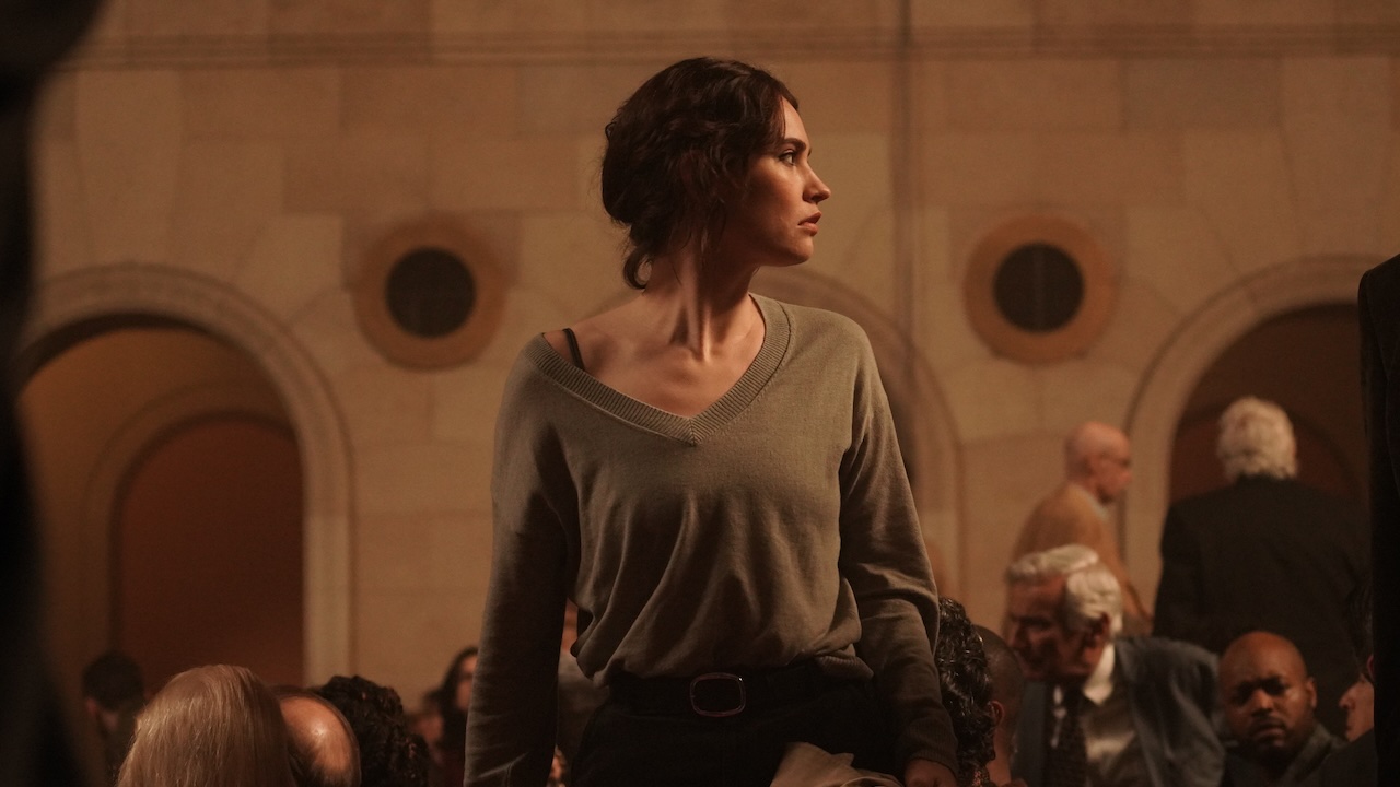 Lily James standing in an auditorium in Relay