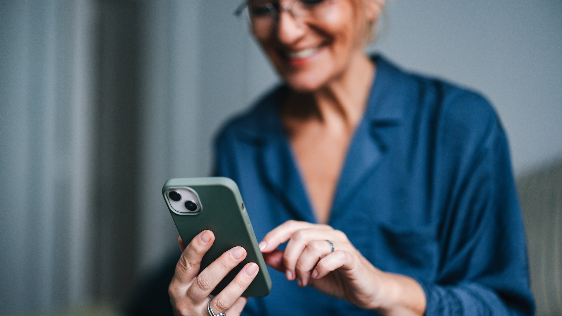 Woman looking at phone in bedroom