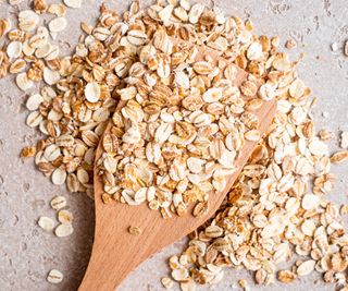 Oats on top of a wooden spoon in the kitchen