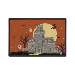 A Halloween doormat with a haunted house illustration