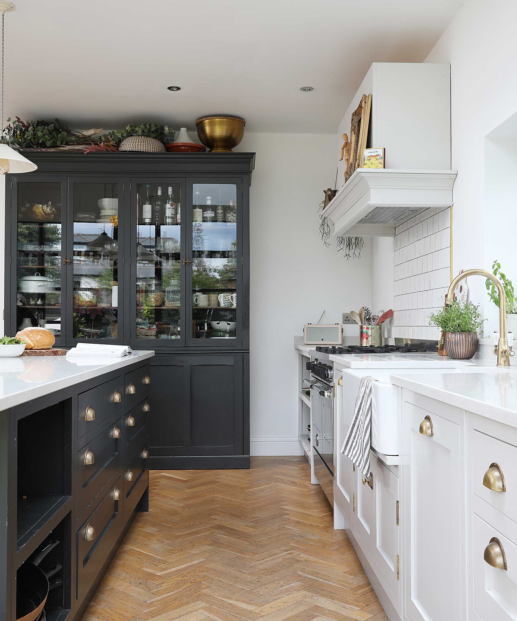 white and dark blue Shaker kitchen with wooden parquet flooring