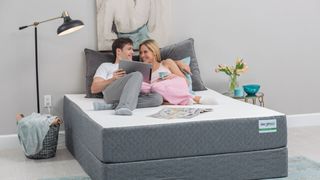 How to choose a mattress for your sleep position: a man and woman read together while lying on a pocket sprung mattress