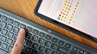 The MX Keys S's emoji button with iPad displaying emoji menu