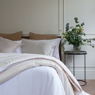 White bedroom with bed covered in duvet