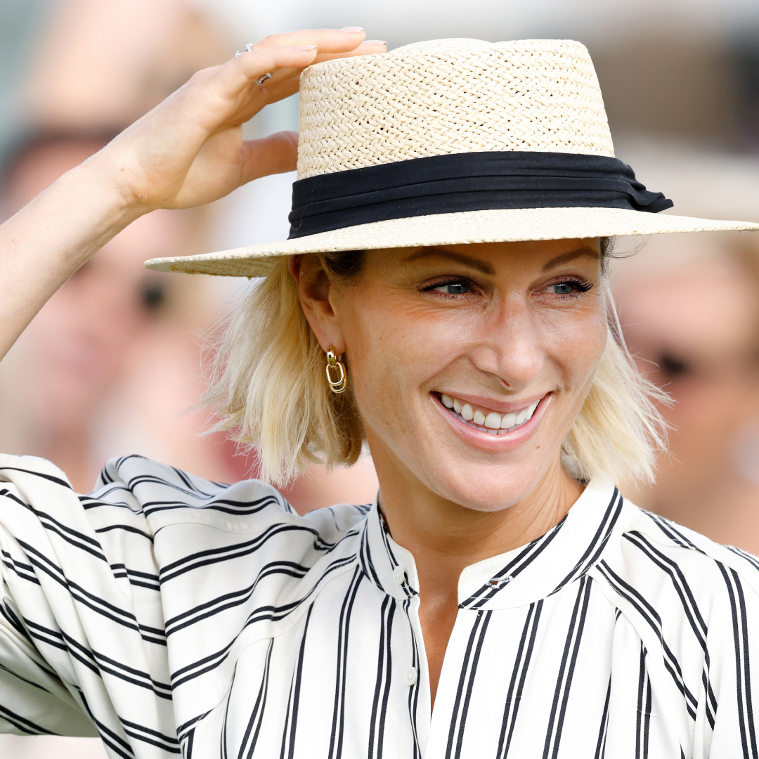Zara Tindall in a straw hat and striped dress smiling