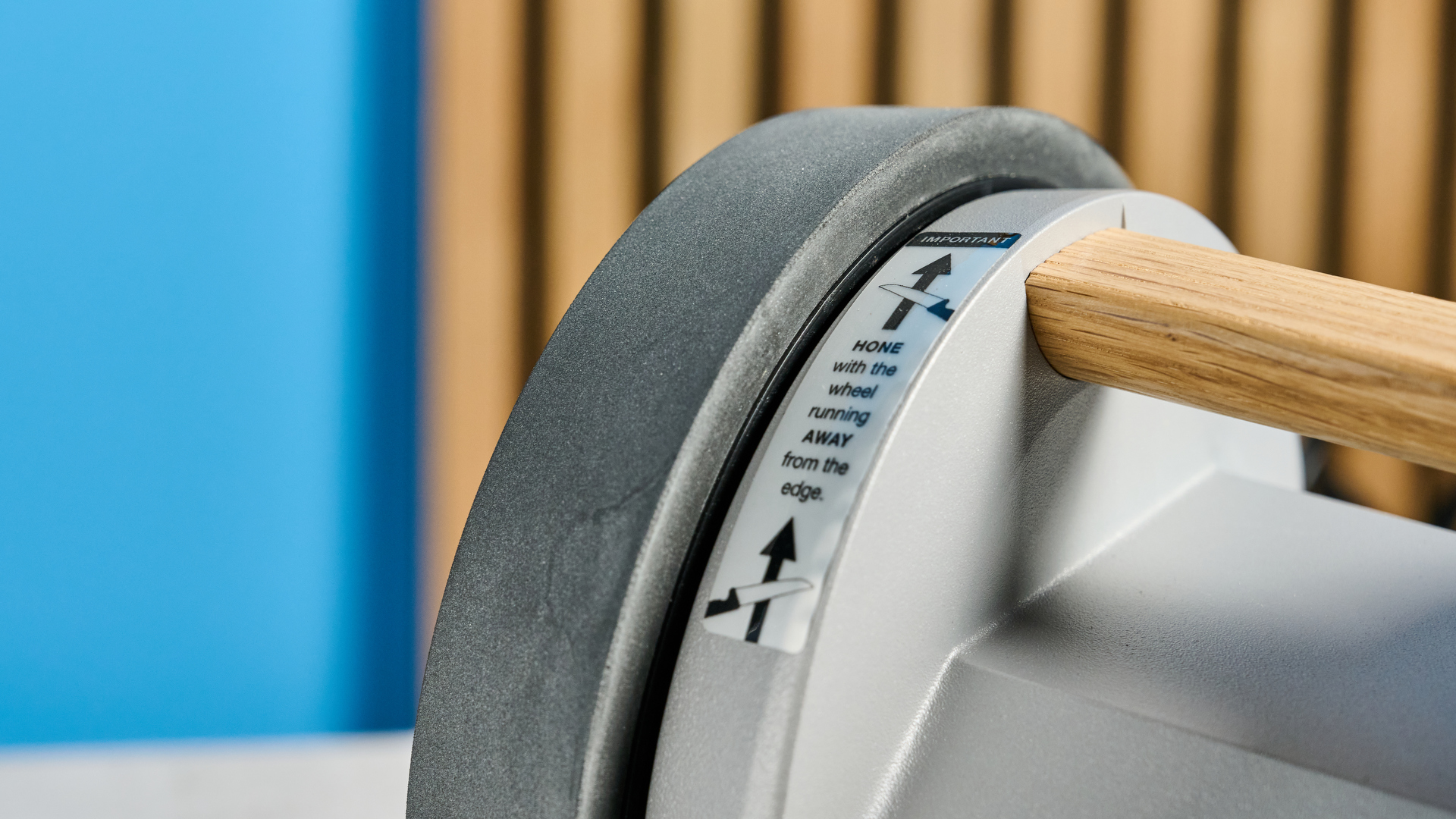 Tormek T-1 knife sharpener on a stone surface with a blue background