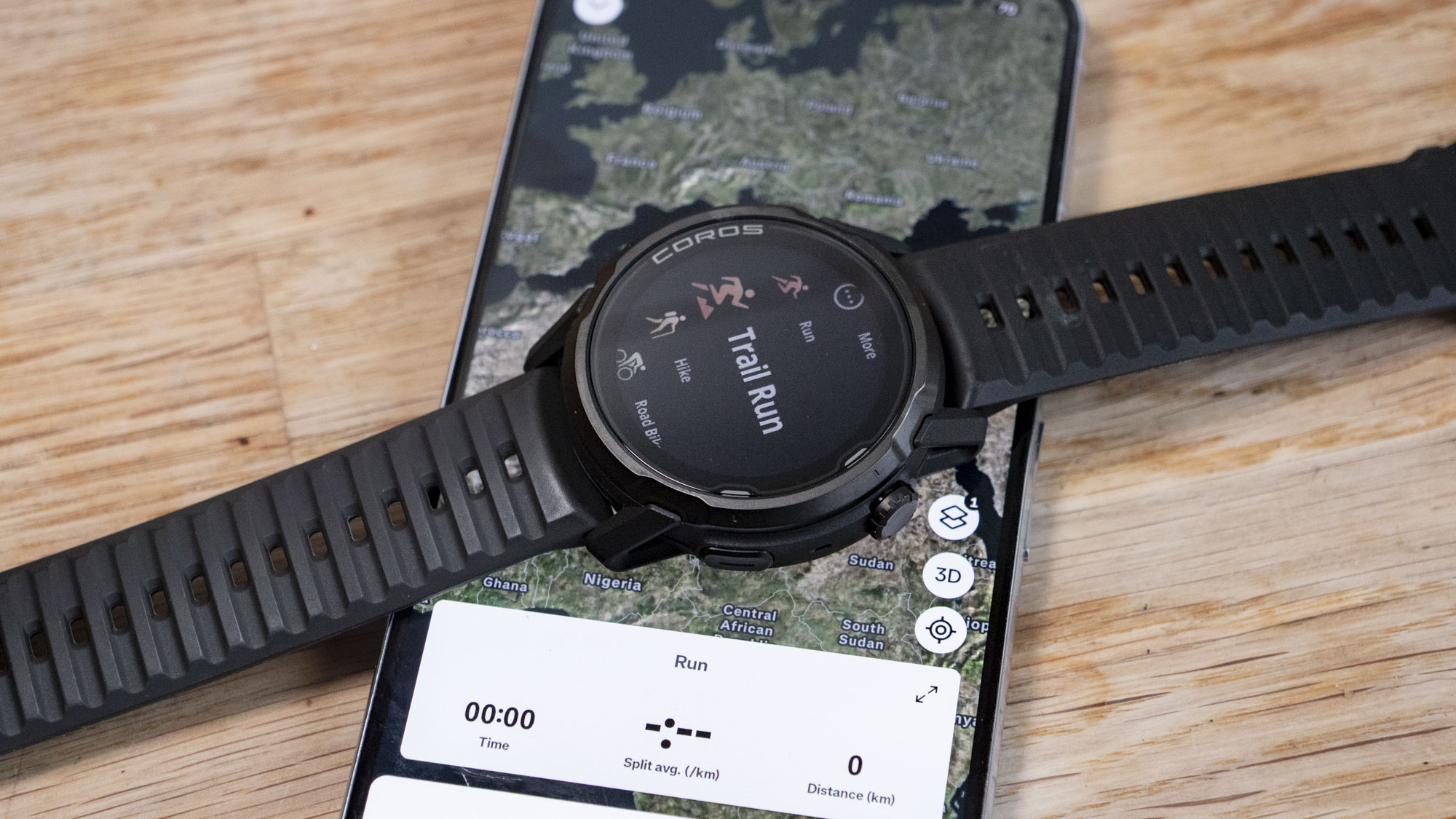Coros Apex 4 running watch resting on top of a phone, with the Strava app UI