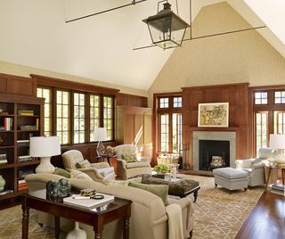 farmhouse style living room with wood panelling, armchairs, sofas, vaulted ceiling, wallpaper, rug, fireplace