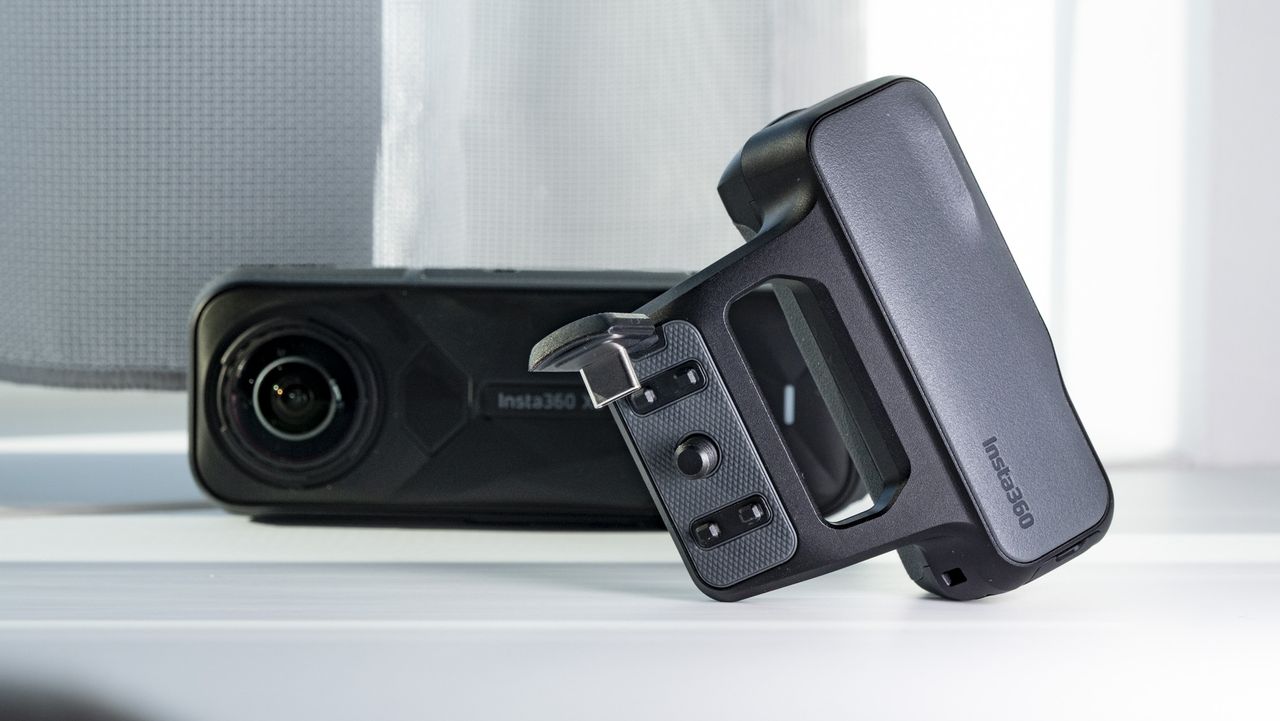 Insta360 X5 Photography Grip alongside to the camera, on a plain white surface