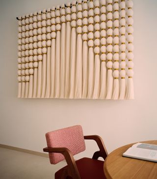 Desk and chair with woven tapestry on the wall below
