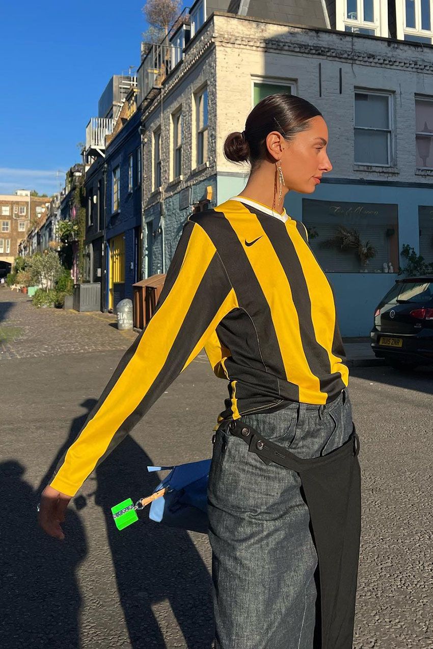A woman wearing a yellow and black striped longsleeve jersey